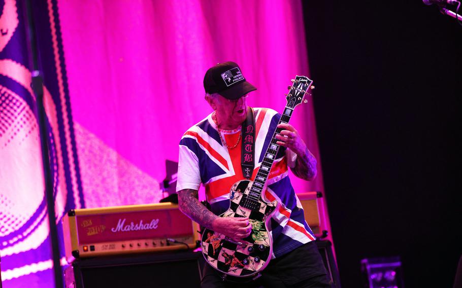 Sex Pistols guitarist Steve Jones sports a Heroes Project hat during a concert.