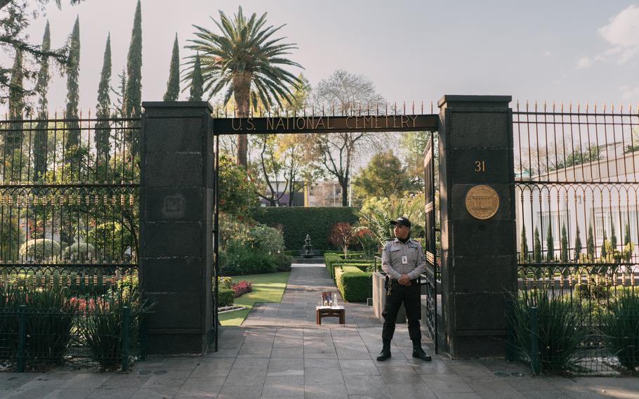 Abraham Leon, a cemetery guard, stands at the entrance of the cemetery.