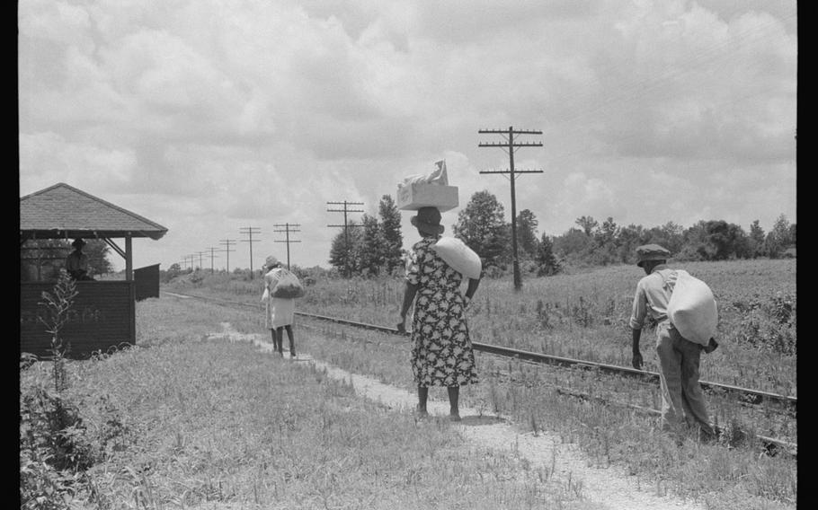 Black residents of Natchez, Miss., walk alongside a railroad track in August 1940. 