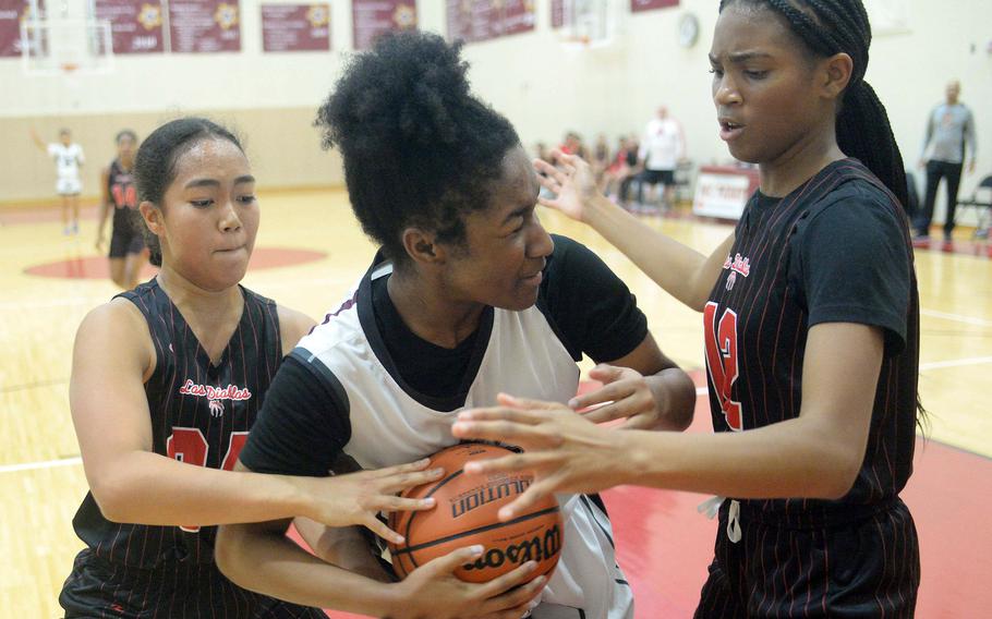 Matthew C. Perry's Keiden Bradley battles Nile C. Kinnick's Kotone Turner and Kamiyah Dabner for the ball during Friday's DODEA-Japan girls basketball game. The Red Devils won 37-14.