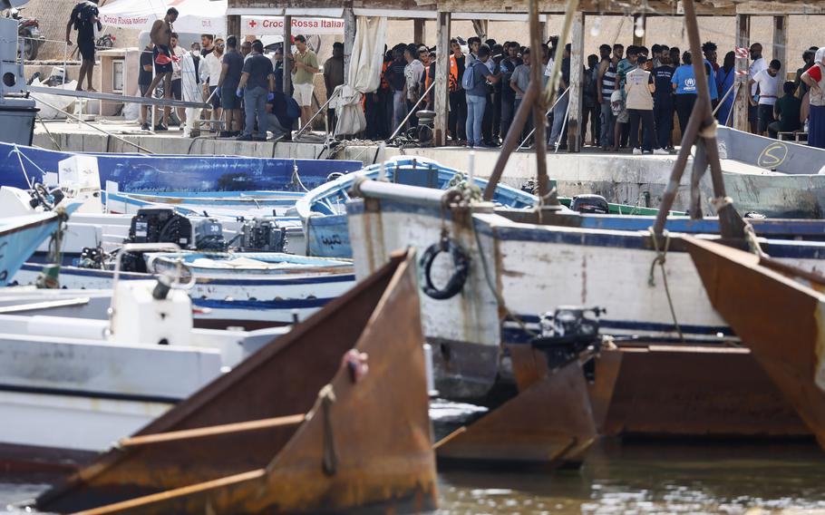 Migrants stand on the dock of the port of the Sicilian island of Lampedusa, southern Italy, Monday, Sept. 18, 2023, a day after European Commission President Ursula von der Leyen visited the island, overwhelmed with thousands of migrants arrivals the past week. 