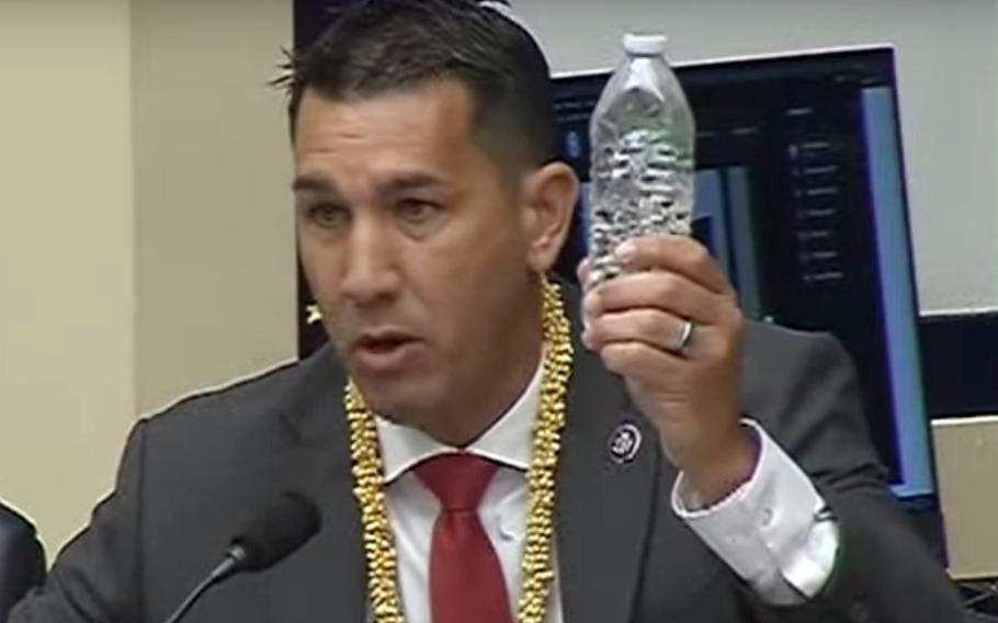 Rep. Kai Kahele, D-Hawaii, holds up a bottle of tainted water collected from a home near Joint Base Pearl Harbor-Hickam, in this screenshot of a video of a House Armed Services Subcommittee hearing on Dec. 2, 2021.