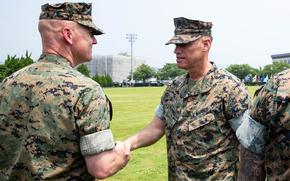 Maj. Gen. Brian Wolford, right, head of Marine Corps Installations Pacific, congratualates Col. Kenneth Rossman, the new commander of Marine Corps Air Station Iwakuni, Japan, July 2, 2025. 