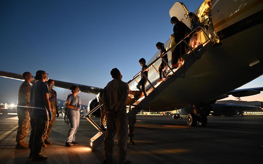  U.S. service members assist evacuees from Afghanistan as they depart a U.S. Navy Boeing C-17A Clipper at Naval Air Station Sigonella, Aug. 28, 2021.