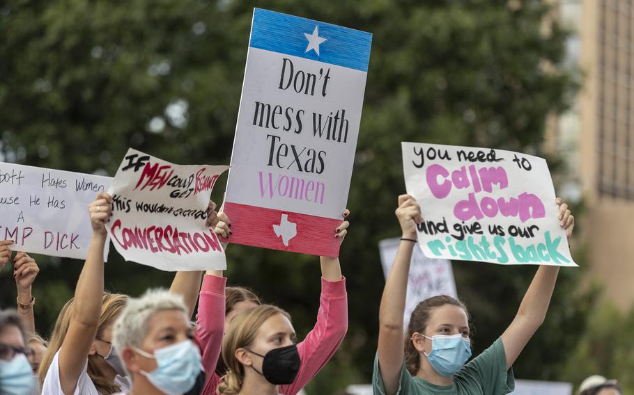 In this Oct. 2, 2021, file photo, people attend the Women’s March ATX rally, at the Texas State Capitol in Austin, Texas. A federal judge has ordered Texas to suspend a new law that has banned most abortions in the state since September. The order Wednesday by U.S. District Judge Robert Pitman freezes for now the strict abortion law known as Senate Bill 8.