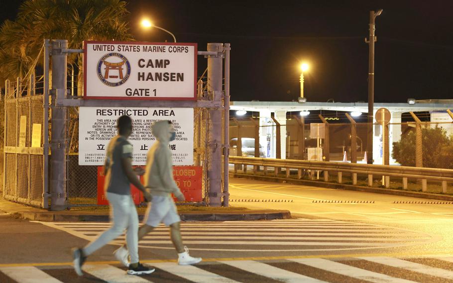 People walk. past the game of the U.S. Marine Corps’ Camp Hansen, in Kin, Okinawa prefecture, southern Japan, on Jan. 6, 2022. 