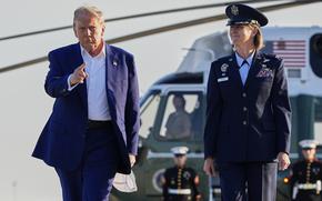 President Donald Trump, left, escorted by Air Force Col. Angela F. Ochoa, Commander, 89th Airlift Wing, walks from Marine One to board Air Force One, Tuesday, June 24, 2025, at Joint Base Andrews, Md. (AP Photo/Alex Brandon)