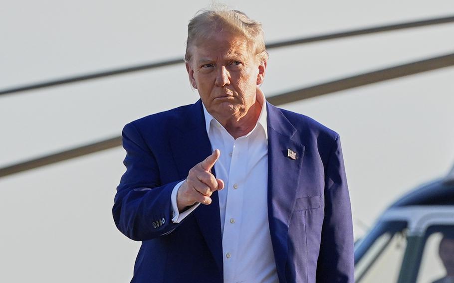 President Donald Trump is escorted by an Air Force colonel as he walks from Marine One to board Air Force One.