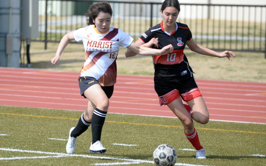 Marist Brothers‘ Riko Noda and E.J. King’s Joanna Hall chase the ball.