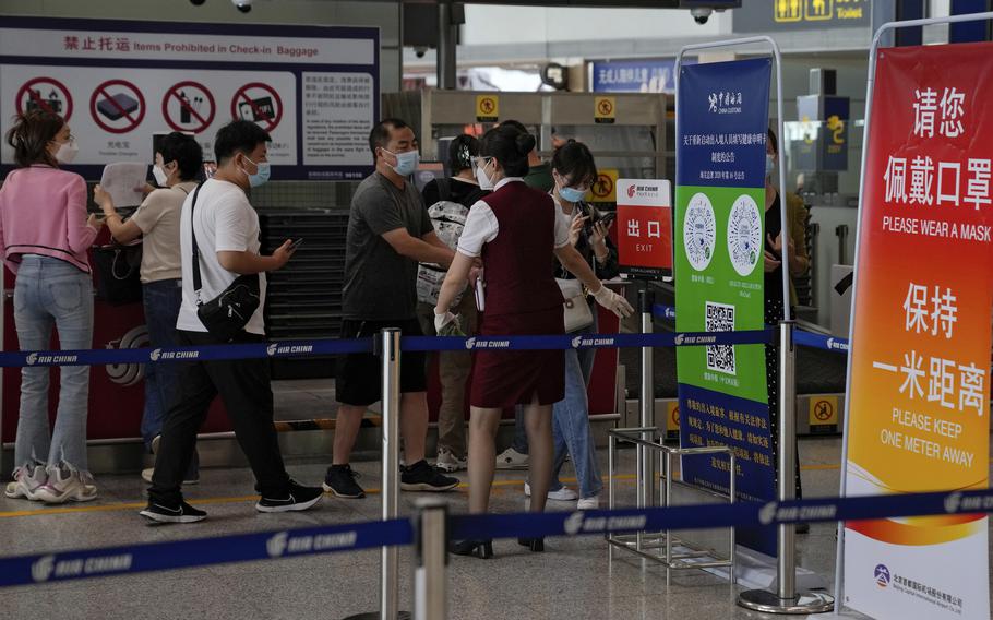 An airliner worker asks travellers to declare their health information after checking in at the international flight check in counter at the Beijing Capital International Airport in Beijing, Aug. 24, 2022. China will reopen its borders to tourists and resume issuing all visas Wednesday, March 15, 2023 after a three-year halt during the pandemic as it sought to boost its tourism and economy.