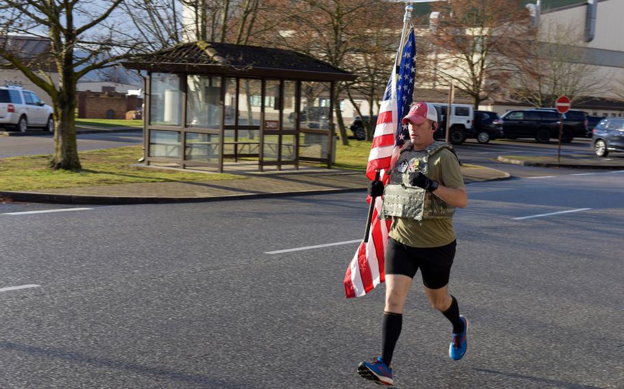 Air Force Master Sgt. Trevor Derr, the flight chief for the 721st Aircraft Maintenance Squadron at Ramstein Air Base, Germany, runs on base, Dec. 7, 2021. Derr always carries a flag during his frequent runs to honor his friend and fellow airman, Tech. Sgt. Daniel Swaney, who died by suicide in 2015 while suffering from post-traumatic stress disorder. Derr also runs to raise awareness of PTSD and to honor all veterans.