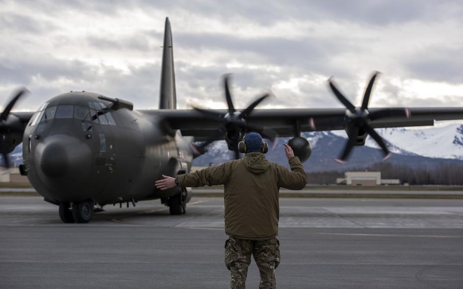 A mechanic directs a C-130J Hercules from RAF Brize Norton, England, during Red Flag drills at Joint Base Elmendorf-Richardson, Alaska, May 4, 2022. 