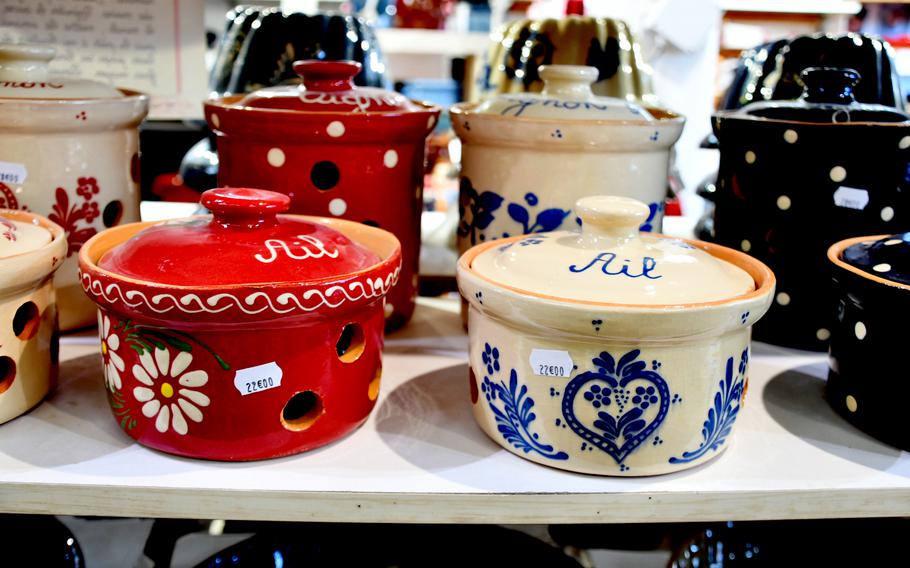 Decorated clay pots for storing garlic (foreground) and onions wait for buyers in the Ernewein-Haas pottery store in Soufflenheim, France, on Nov. 8, 2021. In the background, baking molds for making traditional Alsatian gugelhupf cake are visible.