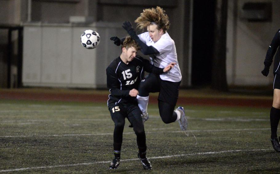 Robert D. Edgren's Ethan Young and Zama American's Aiden Eads collide in a chase for the ball during Friday's DODEA-Japan season-opening soccer match. The Trojans won 4-1.