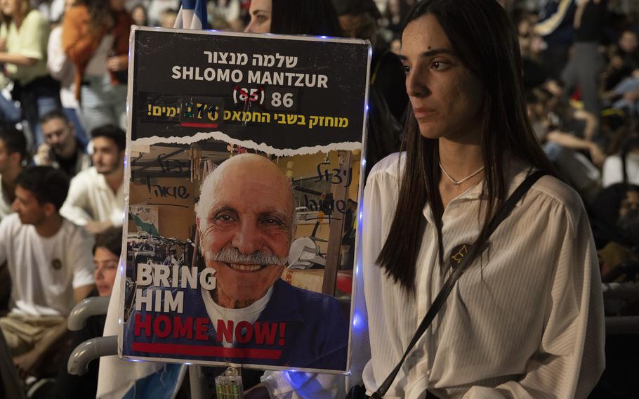 A family member holds a poster of an 86-year-old who is the oldest hostage held by Hamas, in Tel Aviv on Sunday, May 5, 2024. 