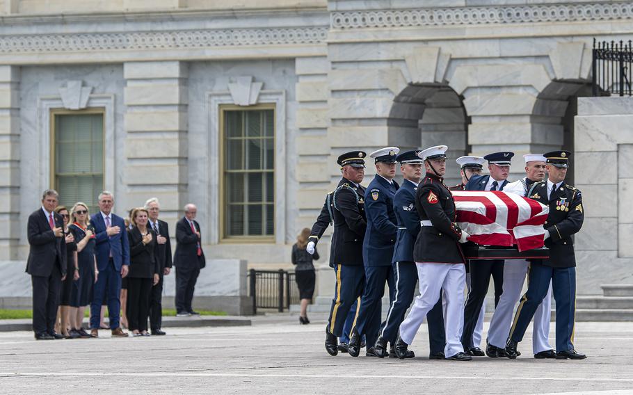 Members of a U.S. military honor guard march to a hearse as they carry the casket of WWII veteran Hershel Woodrow "Woody" Williams after exiting the U.S. Capitol, where Williams was lying in honor for several hours on Thursday, July 14, 2022. Williams, who was the last living Medal of Honor recipient who fought in World War II, died on June 29. He was 98. At left, members of Congress pay their respects with their hands over their hearts as they watch the procession.