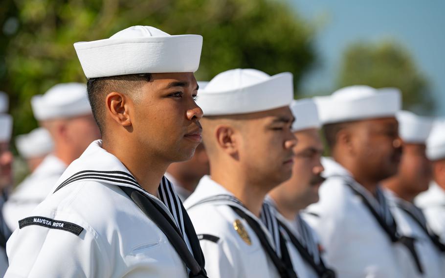 Uniformed sailors stand in formation.
