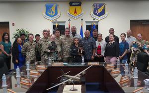 A group of U.S. military members and Guam government officials pose for a photo.