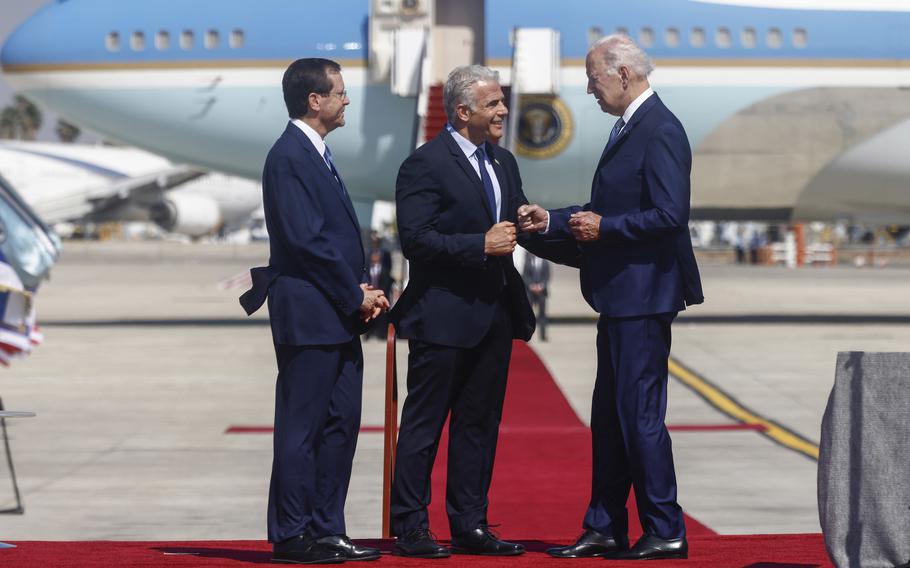 Isaac Herzog, Israel’s president, left, Yair Lapid, Israel’s prime minister, center, and U.S. President Joe Biden, during an arrival ceremony at Ben Gurion International Airport in Tel Aviv, Israel, on July 13, 2022.