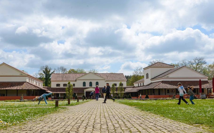 Children play in the courtyard of Roman Villa Borg in Germany, May 2, 2023. The villa complex was built on the original ruins of a Roman buildings and serves as a living history museum. 