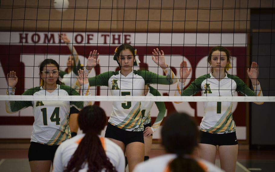 From left, Alconbury Dragons Lana Reyes, Sofia Politis, and Evie Cummings form a front row block, preparing to defend against a serve during the DODEA Division III European volleyball fifth-place match on Oct. 27, 2023, in Kaiserslautern, Germany. The block is a common defensive posture during a serve or when expecting a spike from the opposing team.