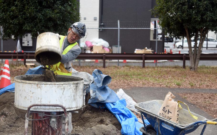 A construction worker mixes cement for a housing project at Yokota Air Base, Japan, Feb. 5, 2024. 