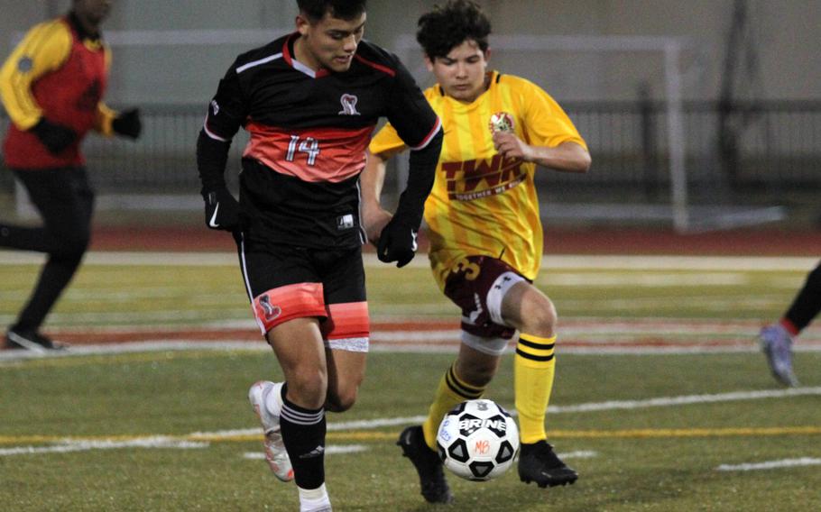 E.J. King's Damien Perez dribbles upfield as Matthew C. Perry's Shayden Torres gives chase during Friday's DODEA-Japan boys soccer season opener at Samurai Field. The Cobras won 3-2.