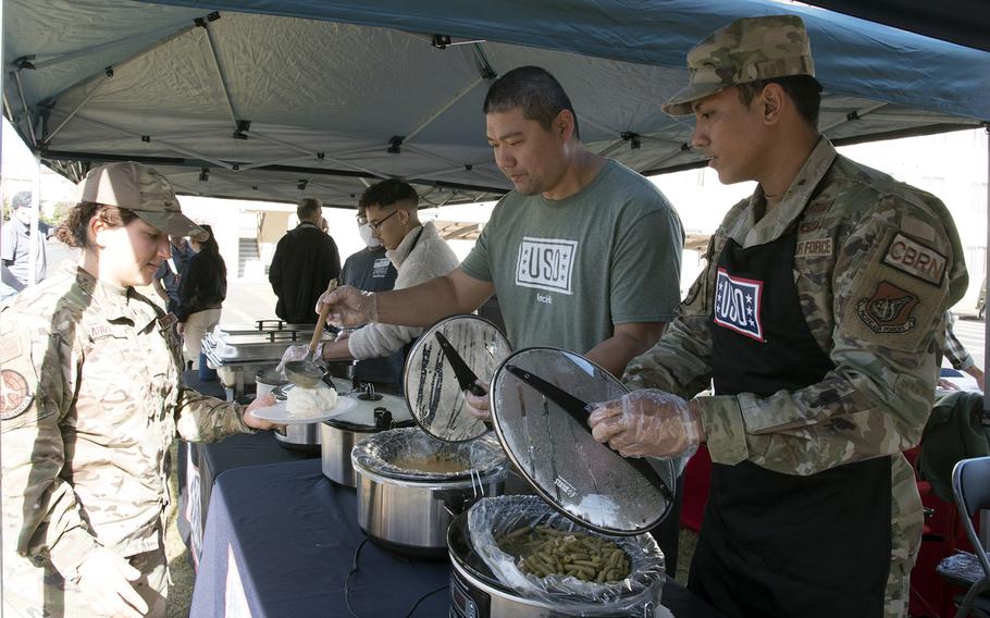 USO volunteers serves single service members a free Thanksgiving meal at Yokota Air Base, Japan, Tuesday, Nov. 22, 2022.