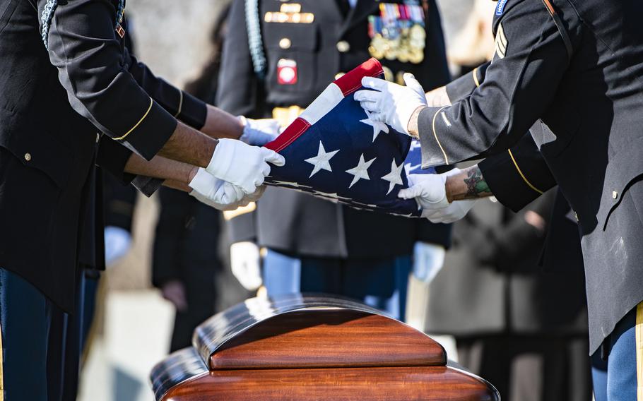 Members of a U.S. Army honor guard fold the American flag above the casket of former Sen. Bob Dole who was buried at Arlington National Cemetery on Feb. 2, 2022.