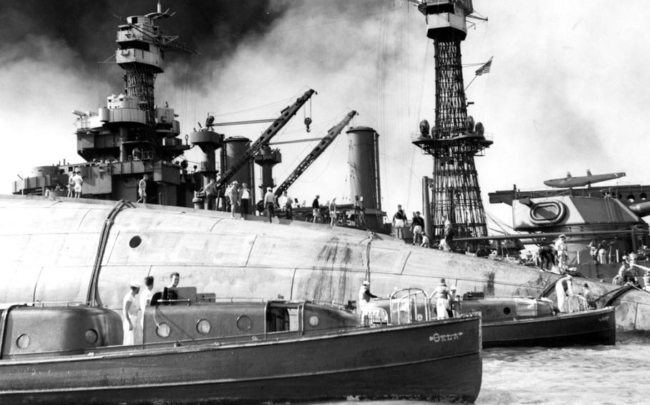 Rescue teams stand on the capsized hull of the USS Oklahoma on Dec. 7, 1941, in an attempt to save crew members trapped inside.