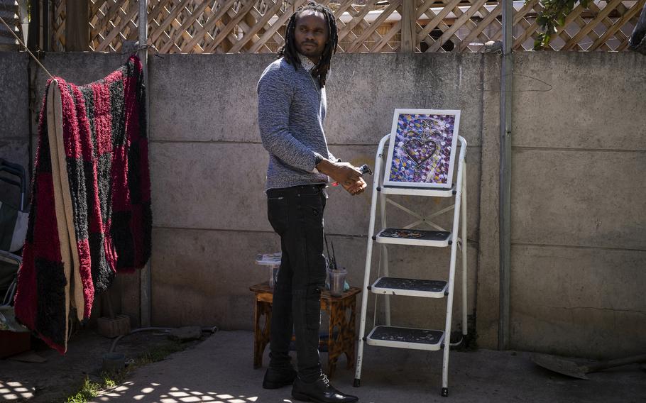 Emmanuel Louis paints in the backyard of his home in Quilicura.