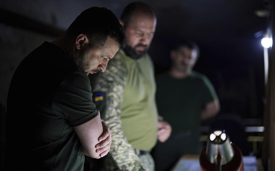 Ukrainian President Volodymyr Zelenskyy, left, listens to a report close to the front line in Donetsk region, Ukraine, on June 5, 2022. 