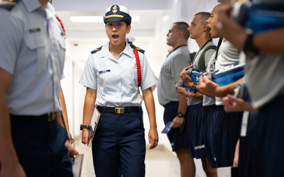 A Coast Guard member gives orders to cadets