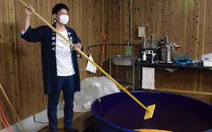 Tadashi Yanagita stirs fermenting sweet potatoes at his family shochu distillery in Miyakonojo City, Japan. 