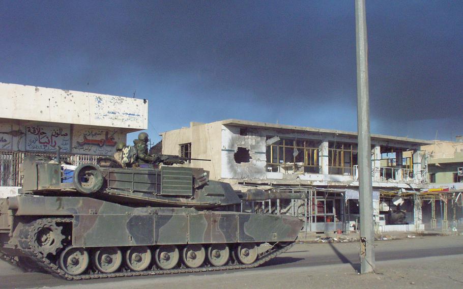 An M1 tank from Battery C of Task Force 1-7 rolls down Highway 1, the main north-south street in Bayji, Iraq, Nov. 25, 2004. The street had been shut to daytime traffic, except for U.S. supply convoys, because of rebel attacks.