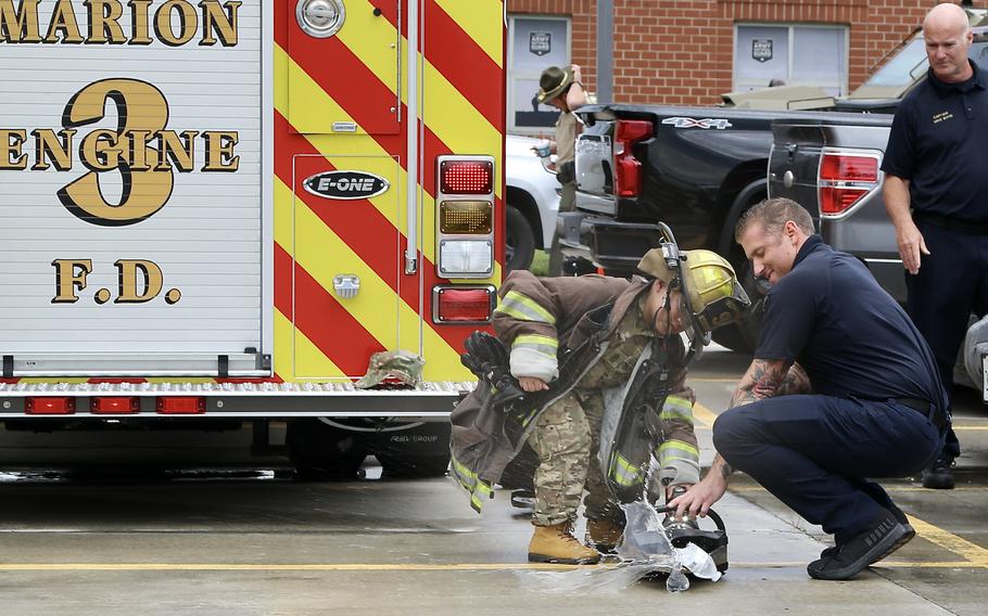 Jamir Gibbs, 7, of Marion, Ill., uses a Marion Fire Department “Jaws of Life” to crush a water bottle after his “promotion” ceremony. J