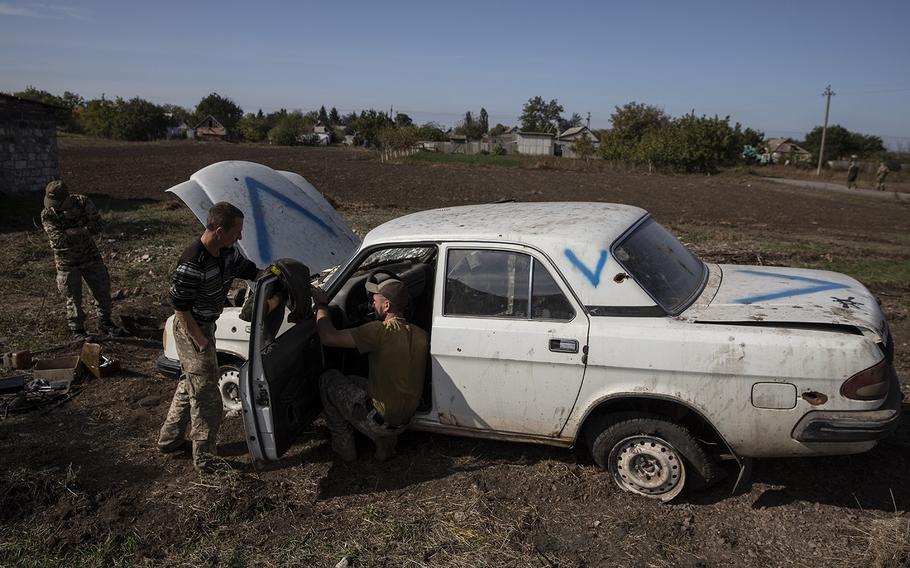 Ukrainian soldiers by an abandoned vehicle Sunday in the Kherson region. 