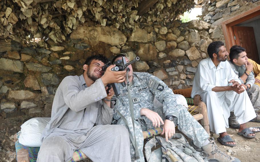 Capt. Jeffrey Hinds, then commander of A Company, 2nd battalion, 327th Infantry Regiment, shares a moment with a villager during a stop at the family home in the troubled Spin Kay village along the Kunar River.