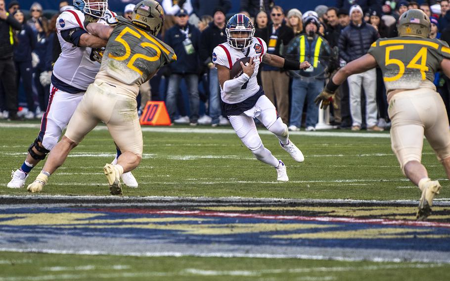 Navy quarterback Xavier Arline (7) runs with the ball as he tries to evade Army defensemen Austin Hill (52) and Camden O’Gara (54) in first quarter play of the annual Army-Navy game played in Philadelphia on Saturday, Dec. 10, 2022.