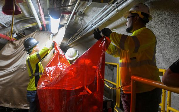 Workers with Joint Task Force-Red Hill set up protective curtains before cutting into pipelines at the Red Hill Bulk Fuel Storage Facility in Hawaii on March 11, 2024.