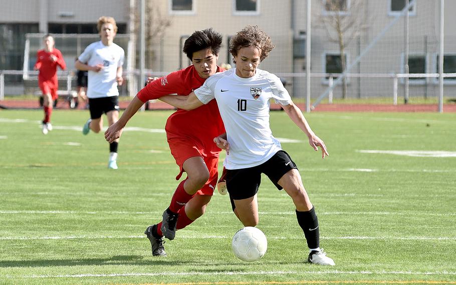 Stuttgart forward Ryan Stevenson muscles off a challenge from Kaiserslautern defender Gavin Cahanding during a boys soccer match on March 9, 2024, at Kaiserslautern High School in Kaiserslautern, Germany.