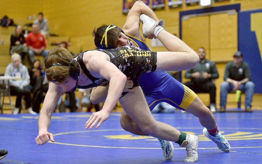 Wiesbaden's Munro Davis picks up the leg of Stuttgart's Aidan Morgan during the 132-pound title bout at the Warrior Wraggle on Jan. 13, 2024, at Wiesbaden High School in Wiesbaden, Germany.