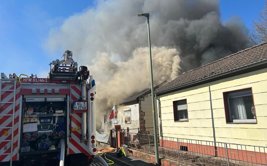 Firemen spray water on a burning house