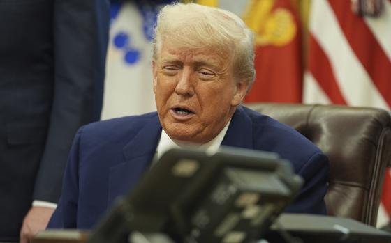 President Trump seen in-focus speaking behind an out-of-focus landline phone in the foreground.