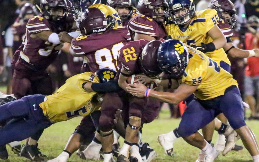 Father Duenas senior running back Caiyle Gogue, Guam's league co-MVP, ran 24 times for 196 yards and had 123 punt-return yards, when he was not being tackled by the likes of Guam High's Laethian Gumaban, left, and Randy Angoco.