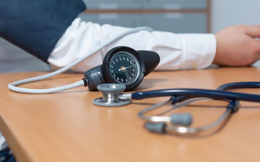 Blood pressure reader and person’s arm on the table