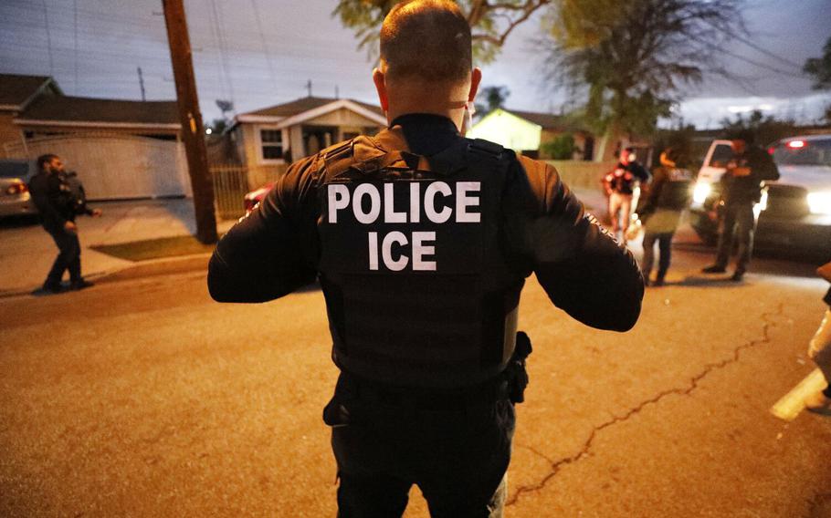 U.S. Immigration and Customs Enforcement agents conduct a pre-dawn apprehension in Bell Gardens, Calif., on March 16, 2020. 