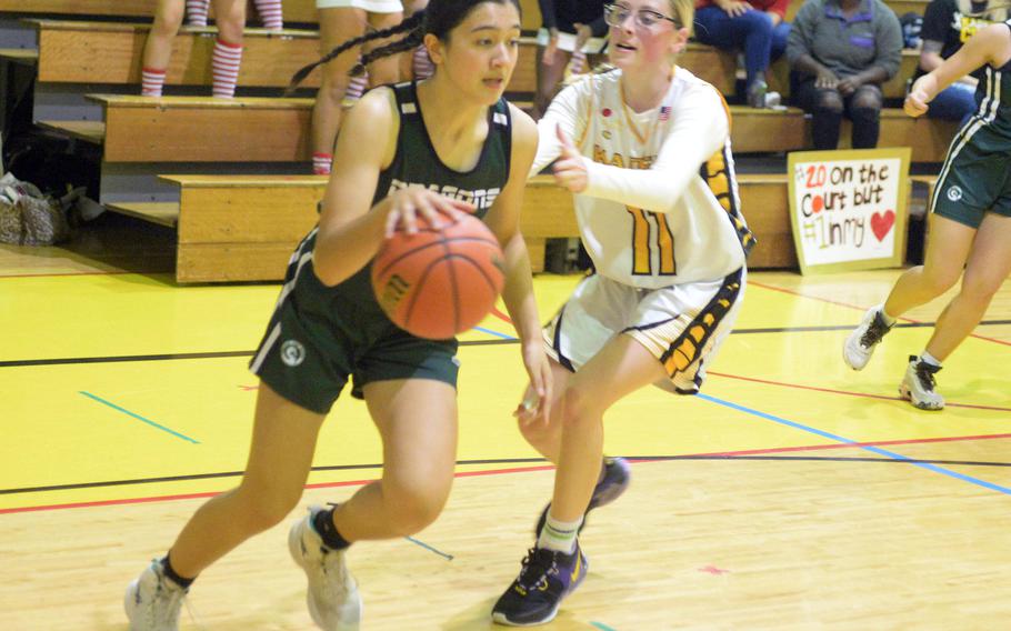 Kubasaki's Runa Holladay drives against Kadena's Cassidy Kimbrough during Friday's DODEA-Okinawa girls basketball game. The Panthers won 44-40, leveling the season series 1-1.