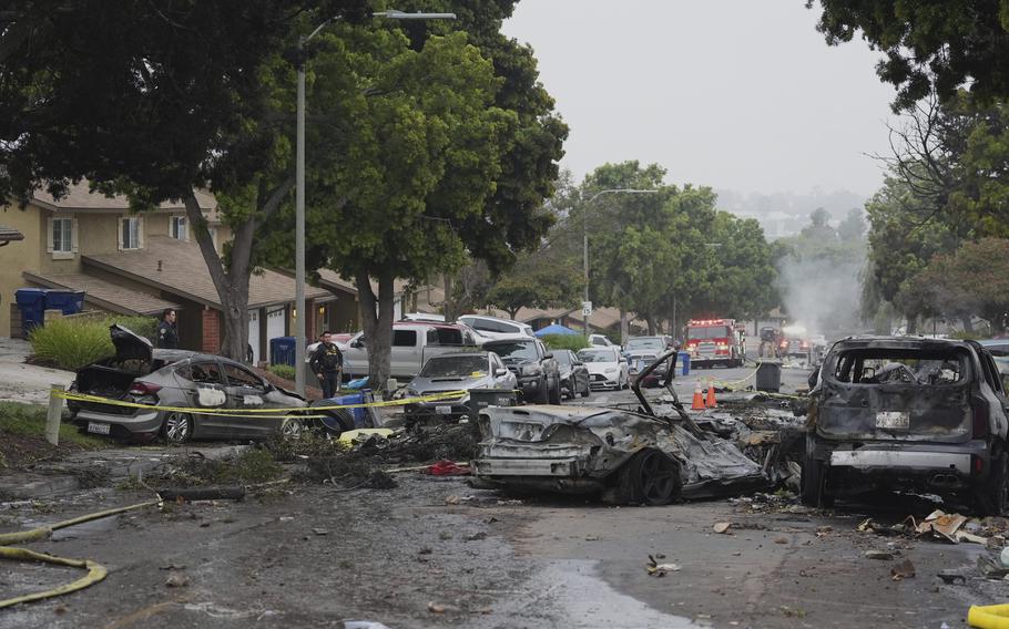A street strewn with debris and damaged cars.