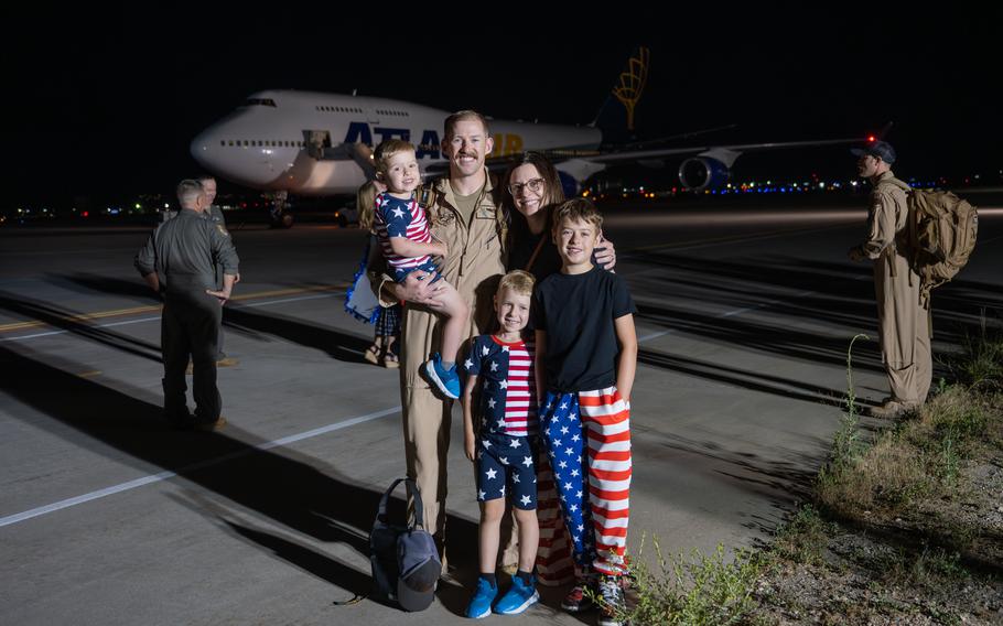 An airman poses for a photo with his family